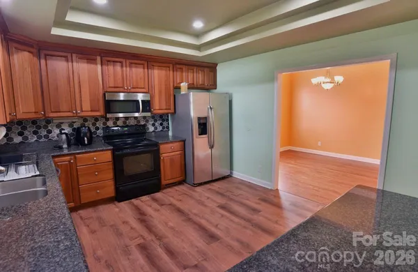 a kitchen with stainless steel appliances granite countertop a refrigerator stove and sink