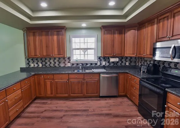 a kitchen with stainless steel appliances granite countertop a stove sink and cabinets