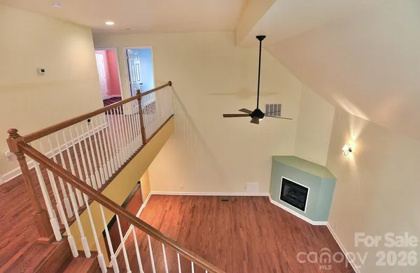 a view of a hallway with wooden floor and staircase