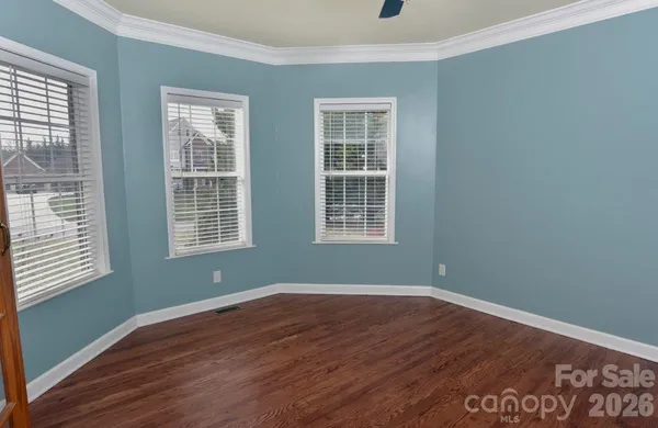 a view of a room with wooden floor and windows