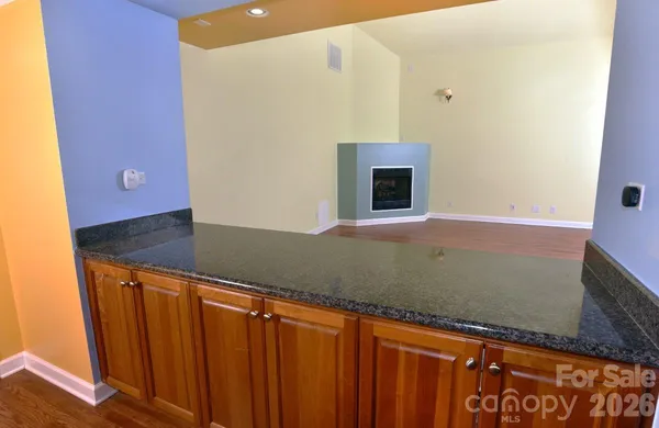 a view of an empty room with wooden floor and a cabinet