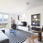 a living room with furniture a large window and a fireplace
