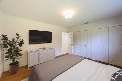a bedroom with a bed and a flat screen tv