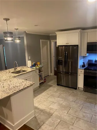 a kitchen with stainless steel appliances granite countertop a refrigerator and a sink