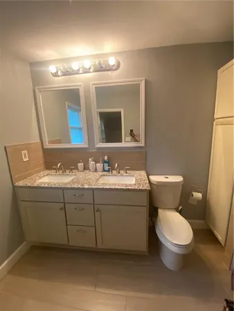 a bathroom with a toilet sink and mirror