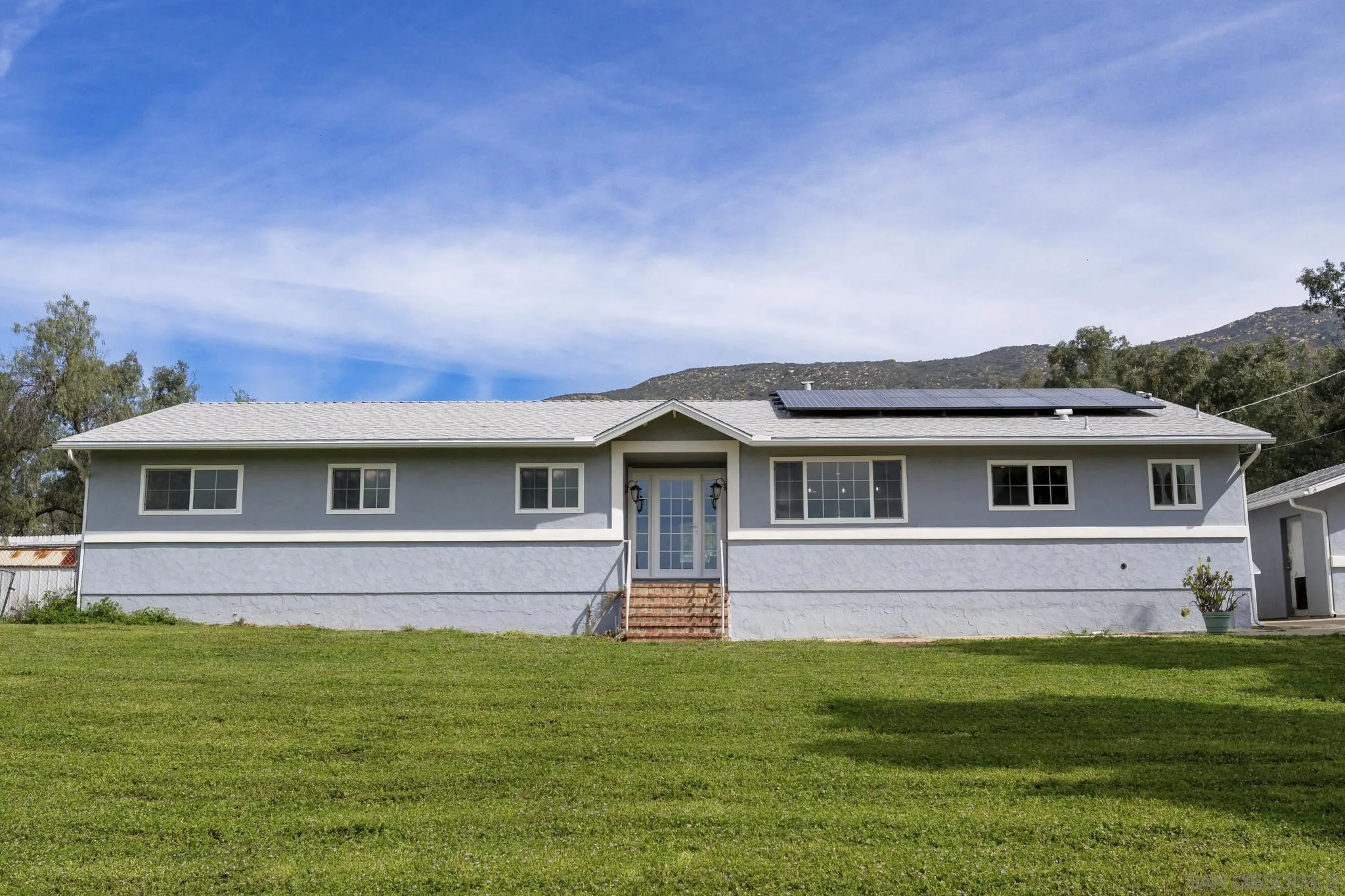 a front view of a house with a garden
