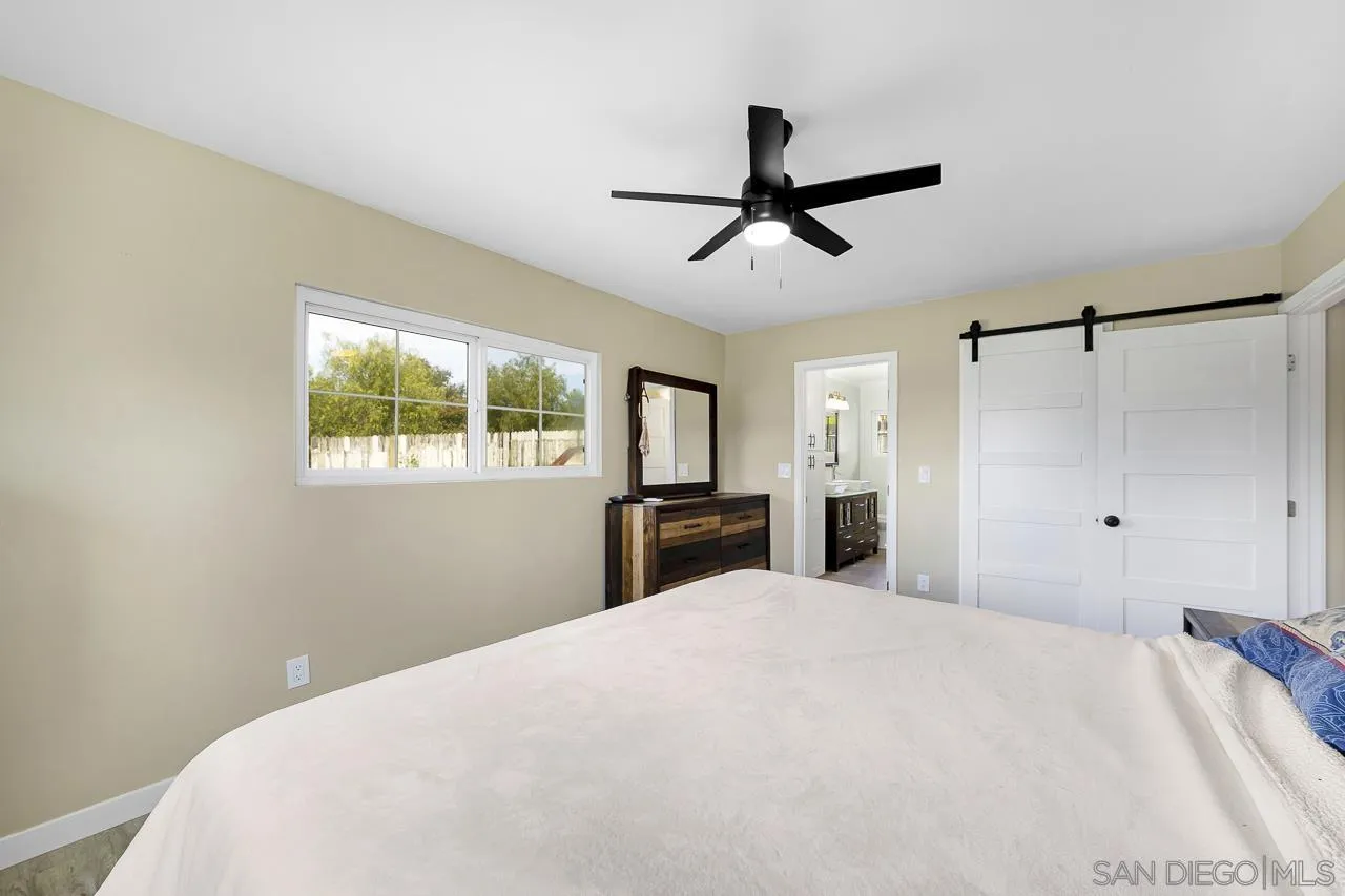 3232 Monterey Crest Drive Jamul, CA 91935 - Photo 21 of 52 a bedroom with a large bed and a chandelier