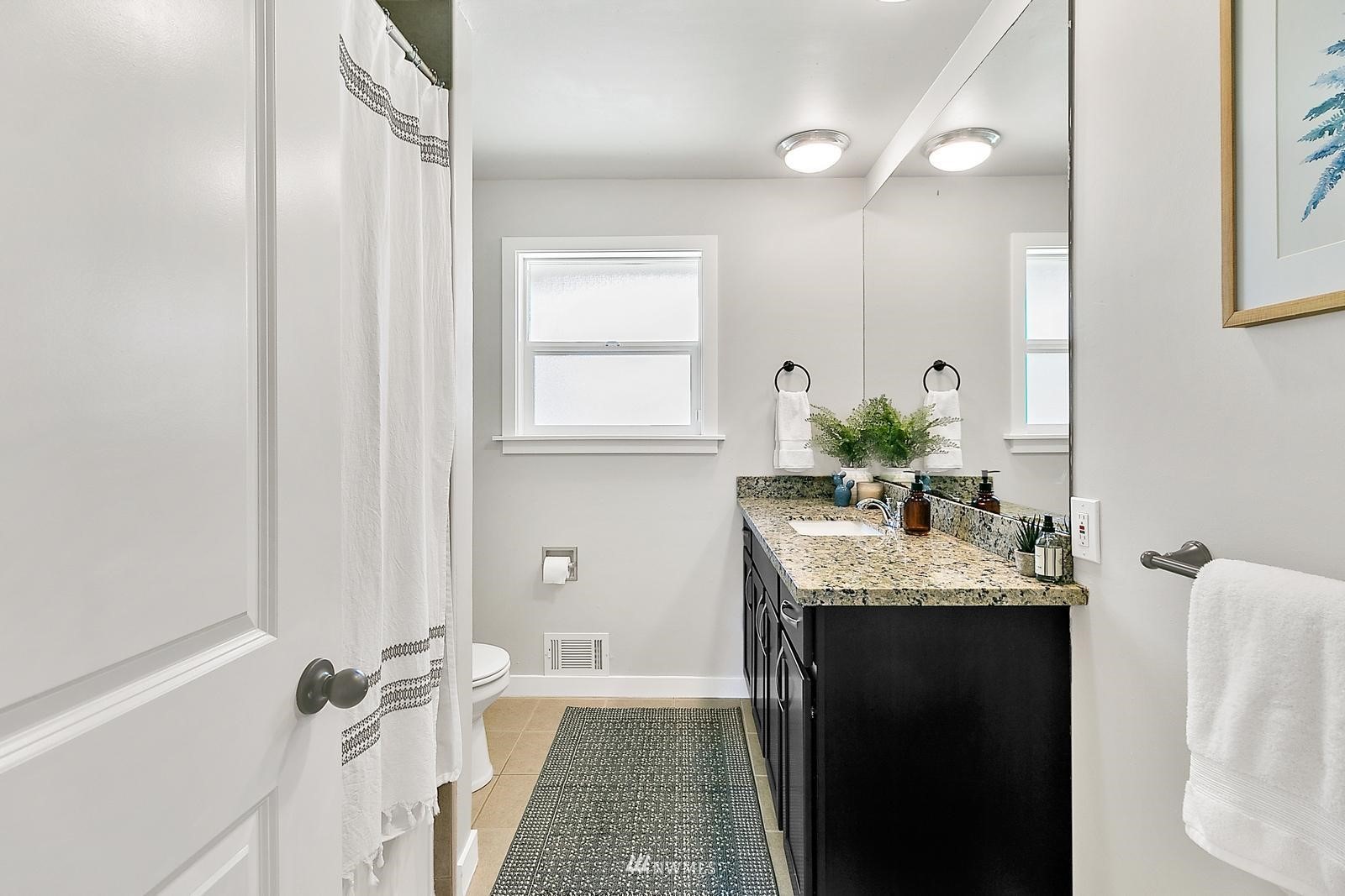 2802 South 304th Street Federal Way, WA 98003 - Photo 14 of 24 a bathroom with a granite countertop sink a mirror a vanity and a bathtub