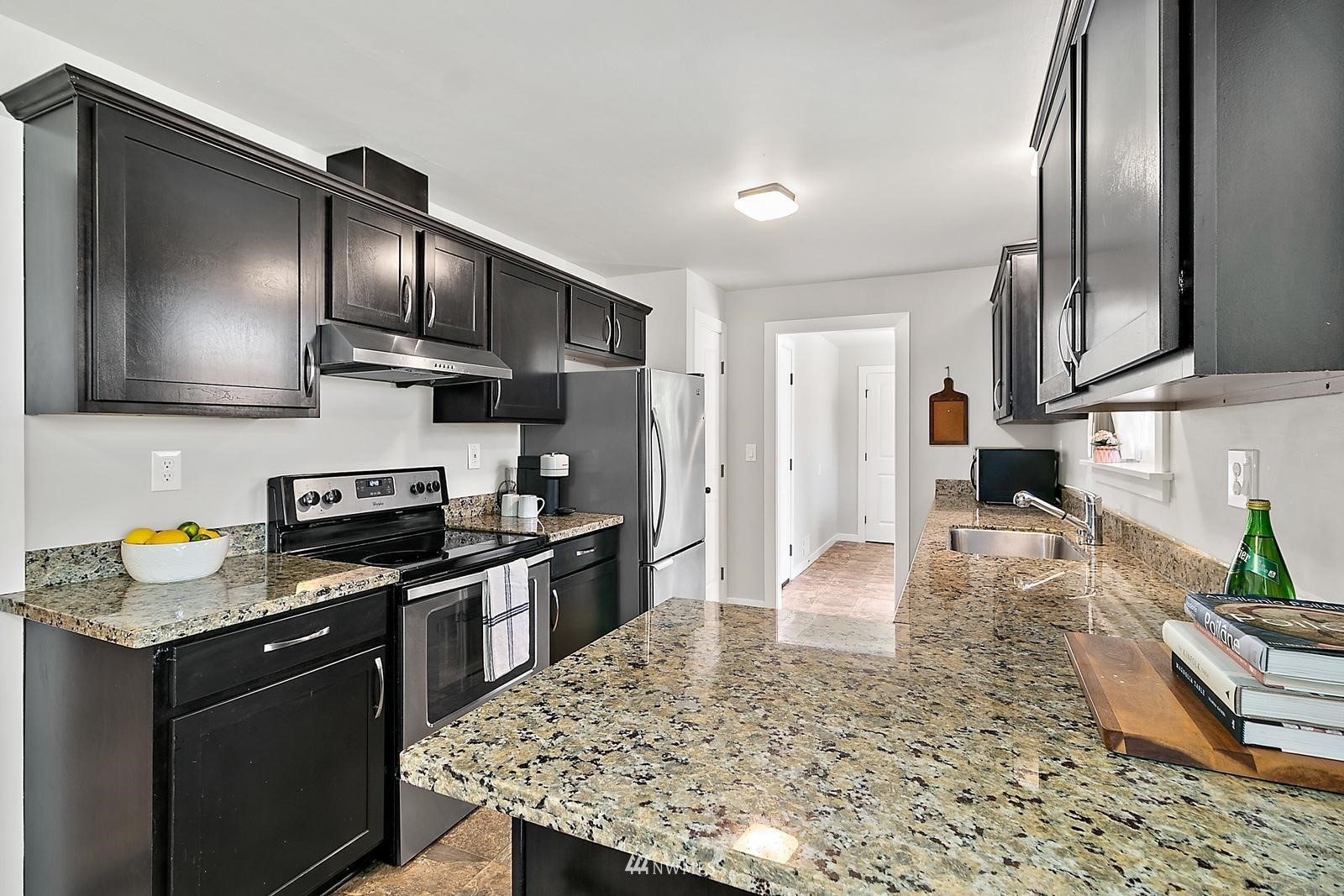 2802 South 304th Street Federal Way, WA 98003 - Photo 8 of 24 a kitchen with granite countertop wooden cabinets a stove top oven and stainless steel appliances