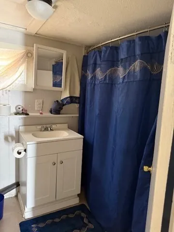 a utility room with a sink a vanity and a mirror