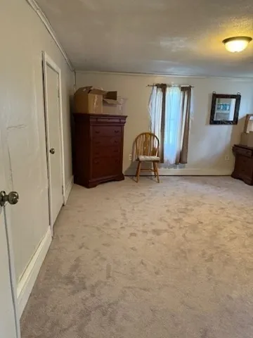a view of an empty room with closet and a window