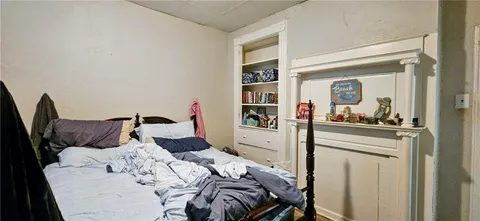 a bedroom with a bed and a mirror on dresser
