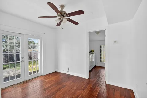 a view of a livingroom with wooden floor and a ceiling fan