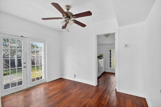 a view of a livingroom with wooden floor and a ceiling fan