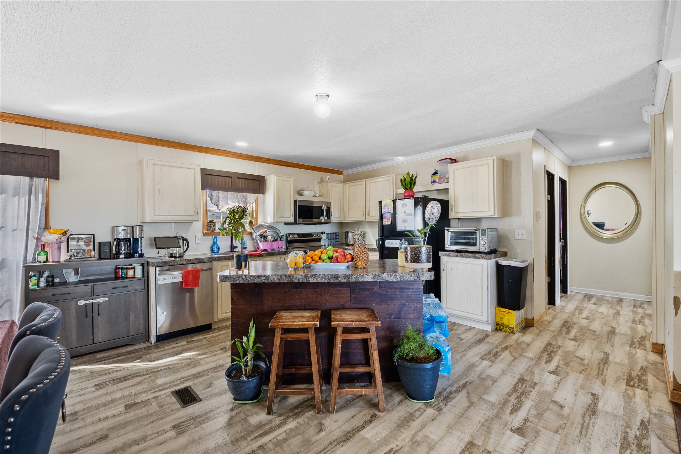 513 Duchess Pass Kyle, TX 78640 - Photo 4 of 16 a kitchen view with stainless steel appliances granite countertop a refrigerator a stove top oven a sink dishwasher and chairs with wooden floor