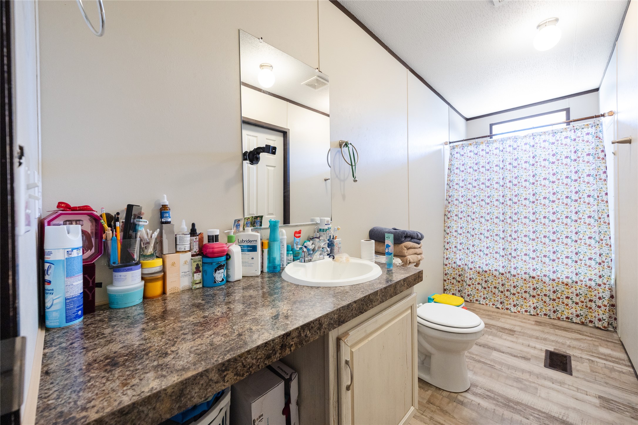 513 Duchess Pass Kyle, TX 78640 - Photo 8 of 16 a bathroom with a granite countertop sink a toilet and a shower curtain