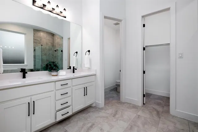 a bathroom with a double vanity sink mirror and toilet