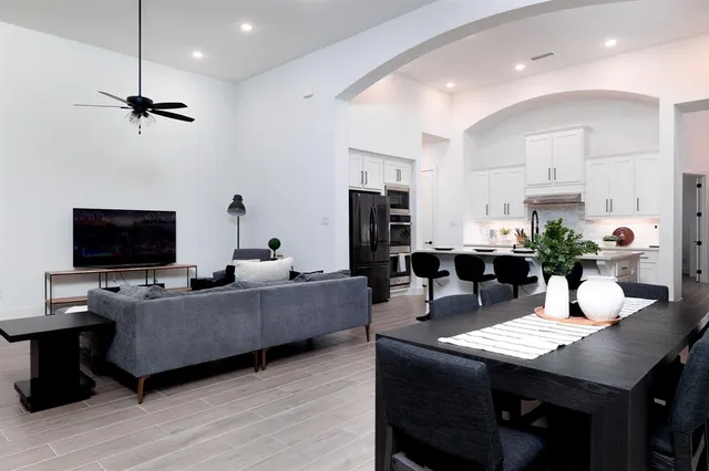 a living room with furniture a flat screen tv and kitchen view
