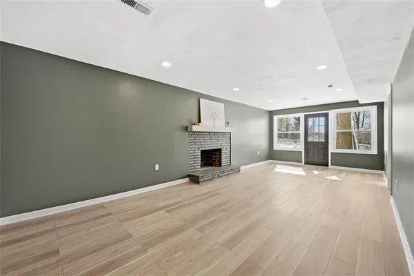 a view of a brick house with wooden floor and fence