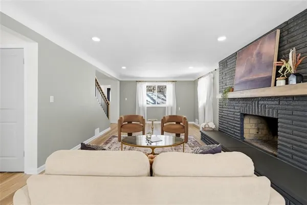 a living room with furniture a fireplace and wall painting