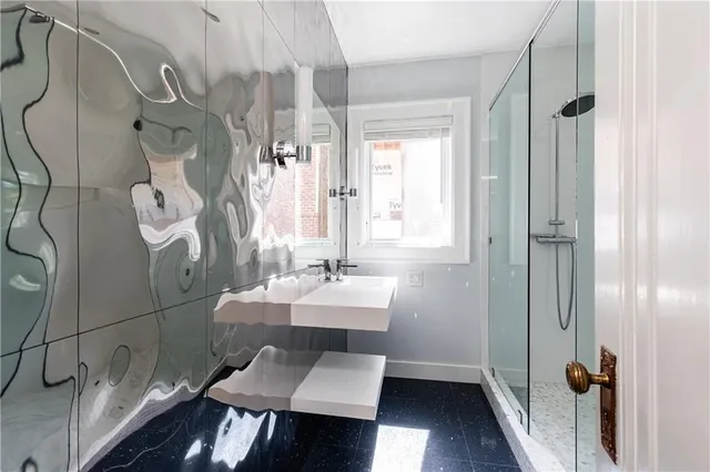 a bathroom with a sink mirror and a shower