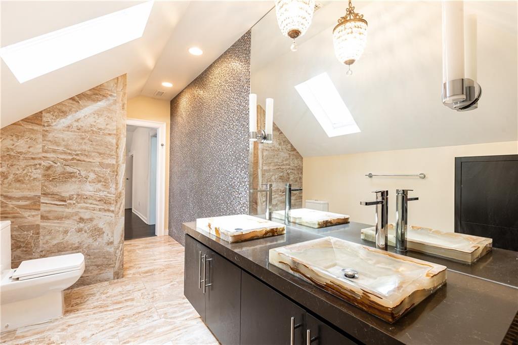 1022 Reeder Circle Northeast Atlanta, GA 30306 - Photo 24 of 37 a bathroom with a double vanity sink toilet and mirror