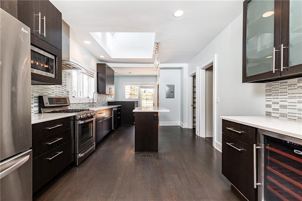 1022 Reeder Circle Northeast Atlanta, GA 30306 - Photo 8 of 37 a kitchen with stainless steel appliances granite countertop a refrigerator a sink dishwasher a stove and white cabinets with wooden floor