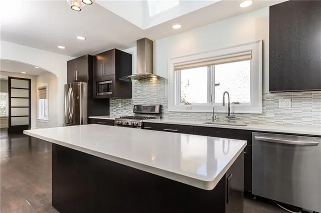 a kitchen with stainless steel appliances a sink stove and refrigerator