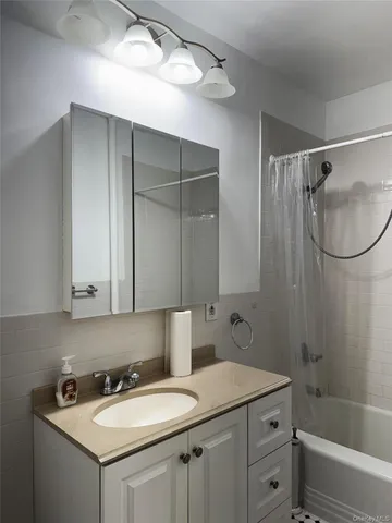 a bathroom with a sink vanity toilet and shower