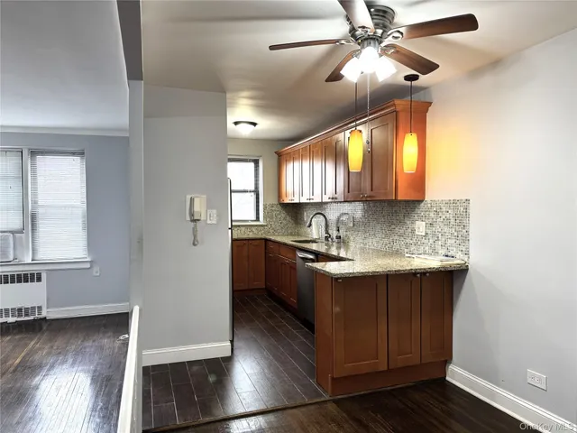 a kitchen with stainless steel appliances granite countertop a sink a stove cabinets and wooden floor