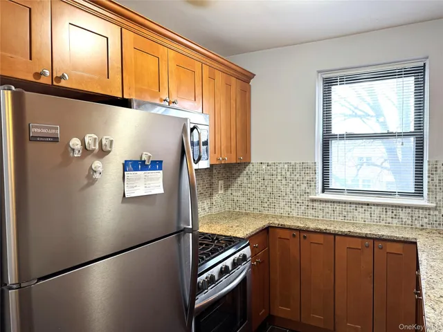 a kitchen with stainless steel appliances granite countertop a refrigerator and a sink