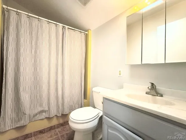 a bathroom with a sink a toilet and shower curtain
