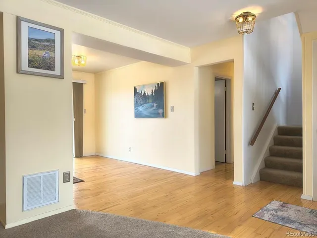 a view of a hallway with entryway wooden floor and front door
