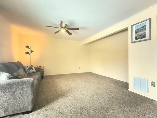 a living room with furniture and a ceiling fan