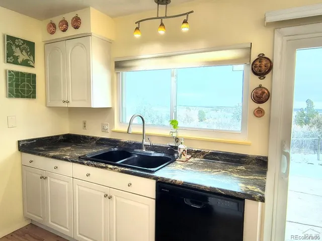a kitchen with granite countertop white cabinets and a stove