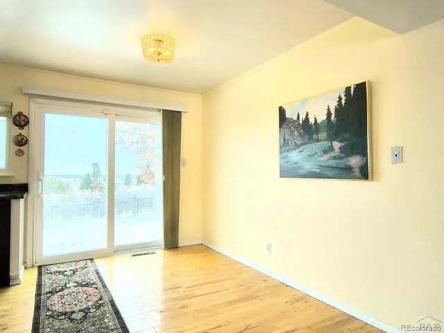 a view of a room with wooden floor and a window