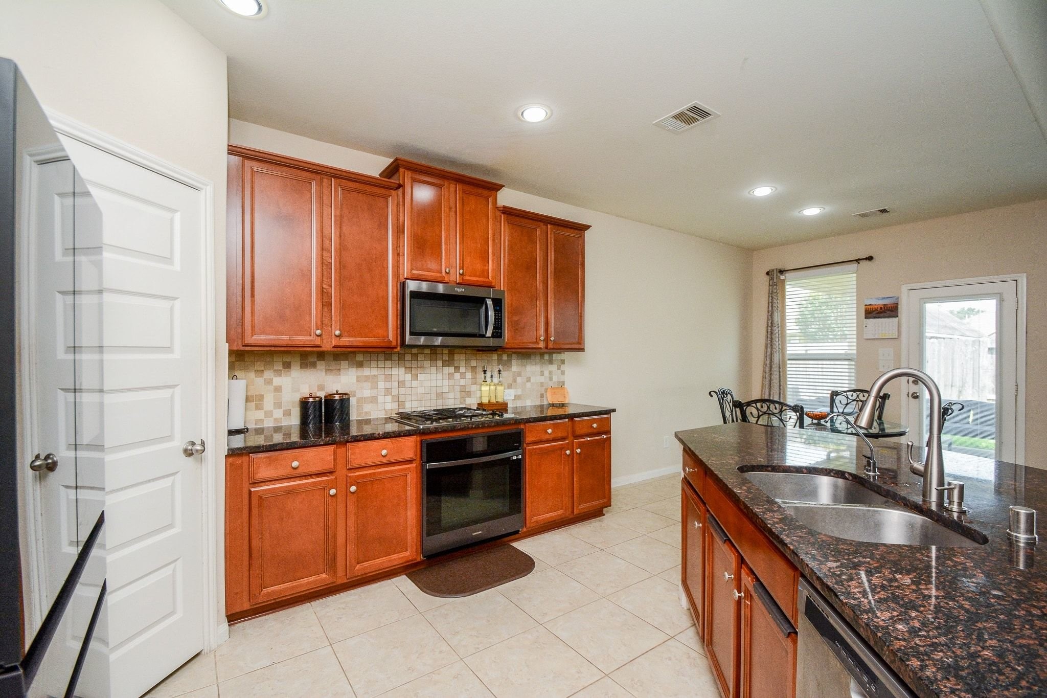7046 Sliding Rock Circle Spring, TX 77379 - Photo 15 of 41 Modern kitchen featuring built-in oven and microwave for seamless cooking.