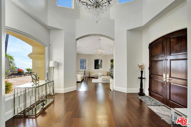 a view of a hallway with wooden floor windows and a living room
