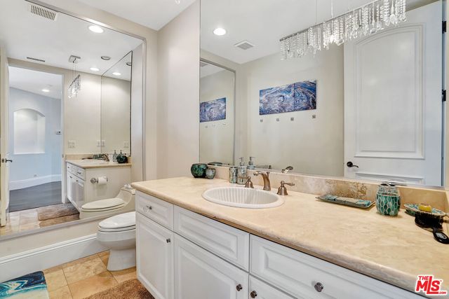 a kitchen with stainless steel appliances granite countertop a stove top oven a sink dishwasher and white cabinets with wooden floor