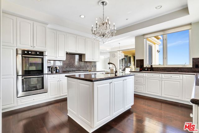 a kitchen with stainless steel appliances granite countertop a sink and cabinets