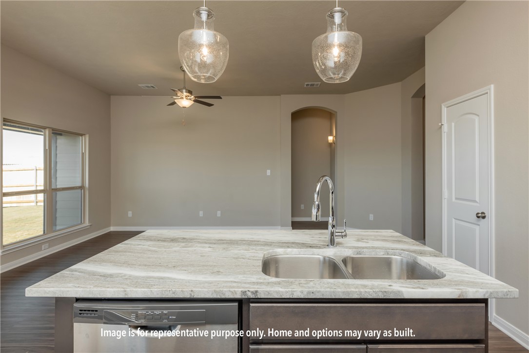 4818 Native Tree Lane Bryan, TX 77845 - Photo 5 of 10 a kitchen with a sink chandelier and a mirror