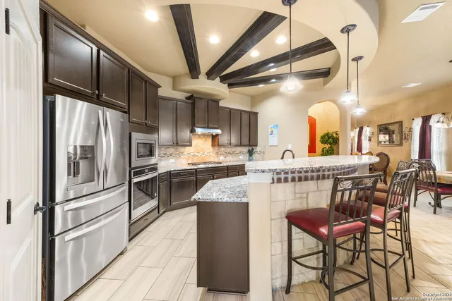 a kitchen with stainless steel appliances granite countertop a stove a sink and a refrigerator