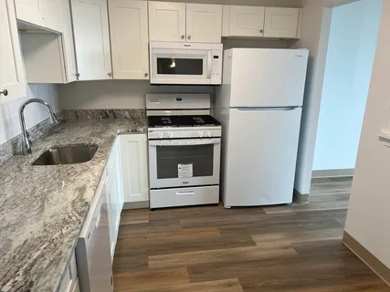 a kitchen with a refrigerator sink and cabinets