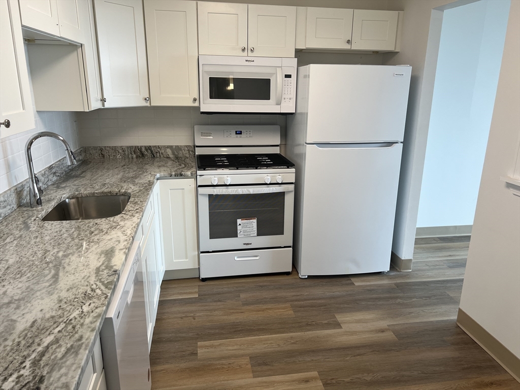 1 Pond Street, Unit 8K Winthrop, MA 02152 - Photo 6 of 14 a kitchen with a refrigerator sink and cabinets