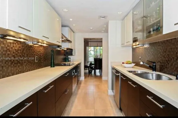 a kitchen with kitchen island a sink a counter top space and stainless steel appliances