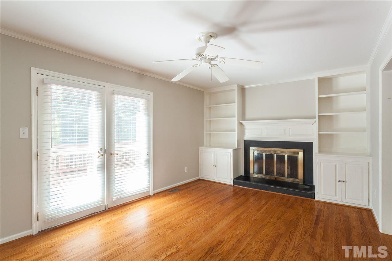 2003 Nancy Ann Drive Raleigh, NC 27607 - Photo 13 of 30 an empty room with wooden floor fireplace and windows