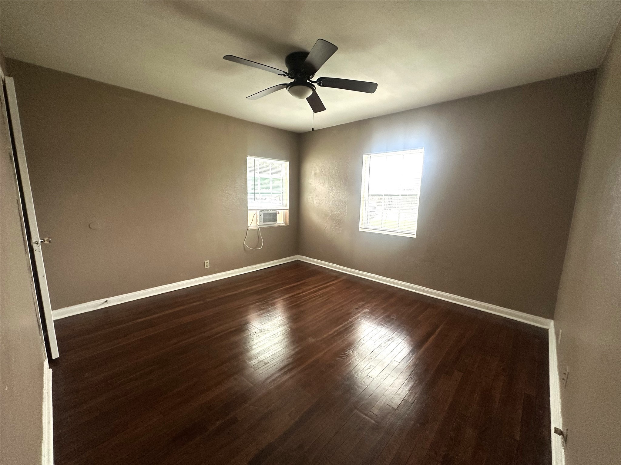 11005 Muscatine Street Houston, TX 77029 - Photo 10 of 12 an empty room with wooden floor and windows