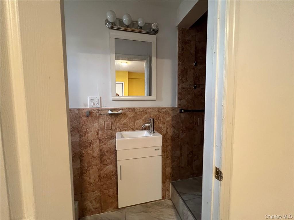 708 Silver Lake-Scotchtown Road Middletown, NY 10941 - Photo 11 of 25 Bathroom featuring a shower, vanity, and tile walls