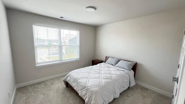 a bed sitting in a bedroom next to a window
