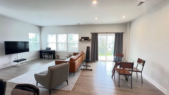 a living room with furniture flat screen tv and a large window